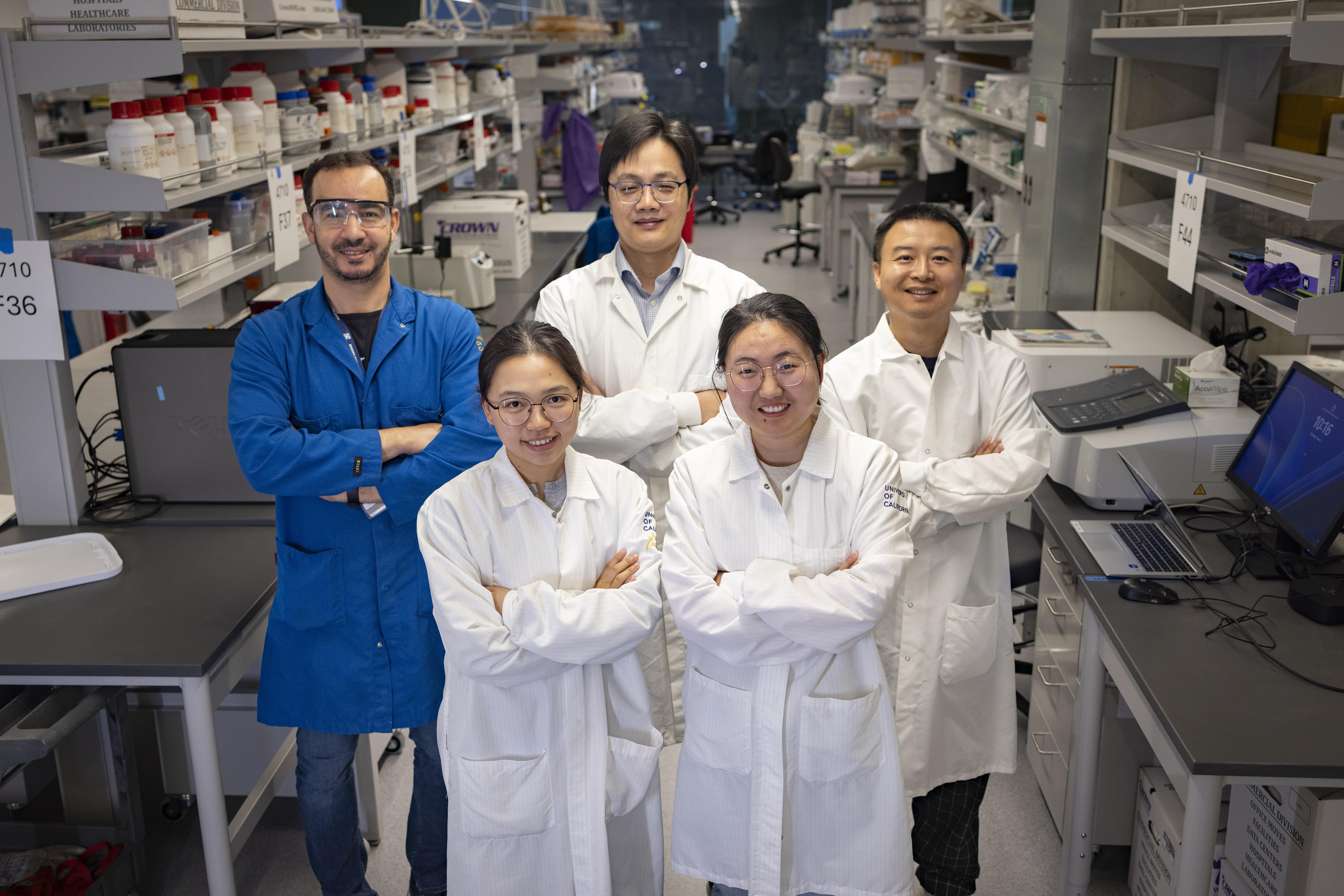 Five scientists pose in front of a laboratory
